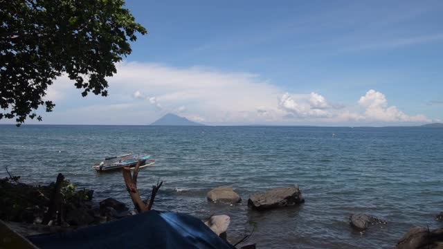 海景。在美丽的景色中，渔船停泊在迷人的蓝色水域，在马纳多市尽头的马纳扬村，背景是马纳多图阿岛(老马纳多)视频素材