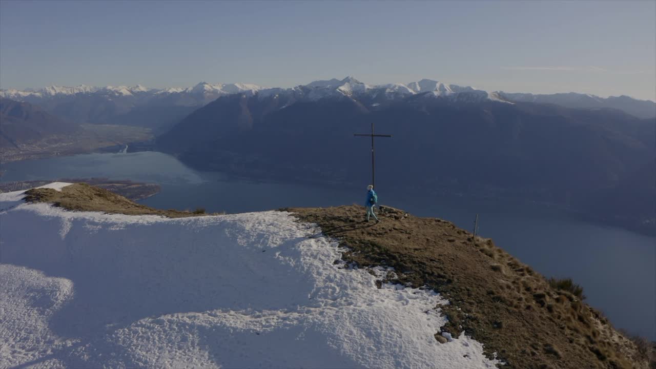 无人机拍摄:年轻成功的徒步旅行者女子在高山顶上的空中手臂，上面是美丽的湖。健康活跃的女性在山顶徒步庆祝视频素材