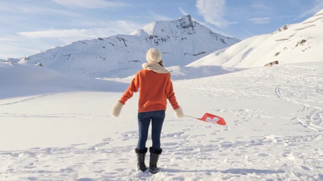 年轻的女子站在高高的雪山在冬天视频素材