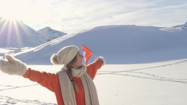 年轻的女子站在高高的雪山在冬天视频素材