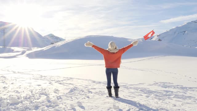 年轻的女子站在高高的雪山在冬天视频素材