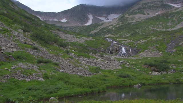 山谷中的湖泊。小溪在青山的一边视频素材