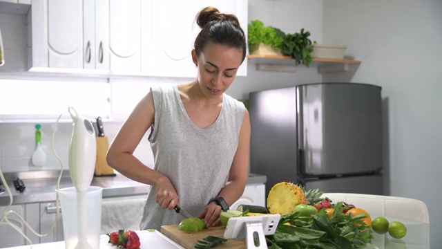 年轻的拉丁美洲妇女在家用智能手机按照网上菜谱做饭视频素材