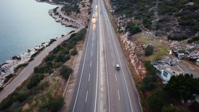 晚上，汽车在沿海岸的高速公路上行驶。航拍镜头视频素材