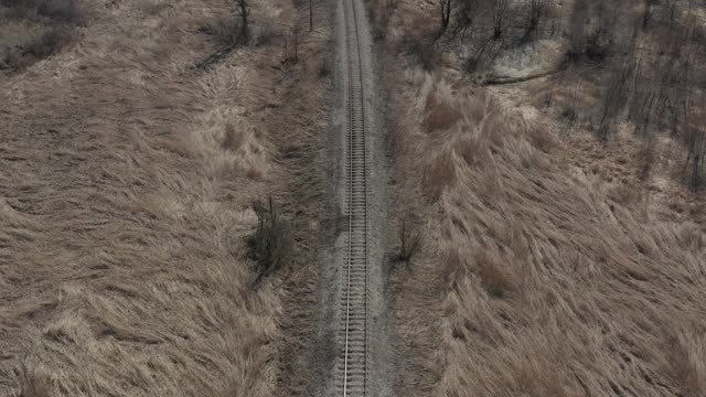 在铁路线路上用4K航拍旱地植物视频素材