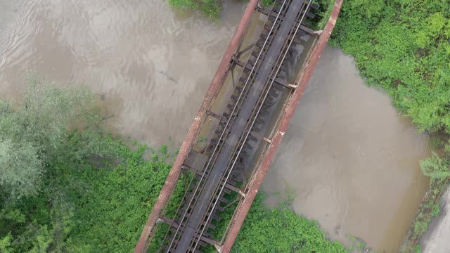 上面的铁路轨道和生锈的桥梁建设4K航拍视频视频素材