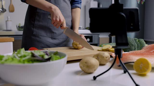 美食视频博主用手机摄像头在家厨房录制视频。展示鲑鱼的烹饪食谱视频素材