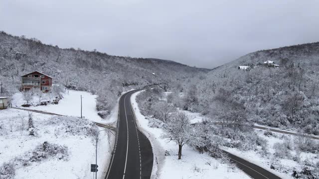 高角度鸟瞰无人机图像上的道路槽的树木和森林在冬季覆盖着白雪的山脉附近的塞尔维亚克纳兹瓦茨-旅游旅程和度假概念视频素材