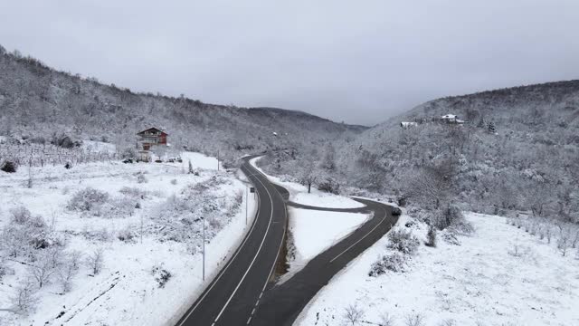 高角度鸟瞰无人机图像上的道路槽的树木和森林在冬季覆盖着白雪的山脉附近的塞尔维亚克纳兹瓦茨-旅游旅程和度假概念视频素材