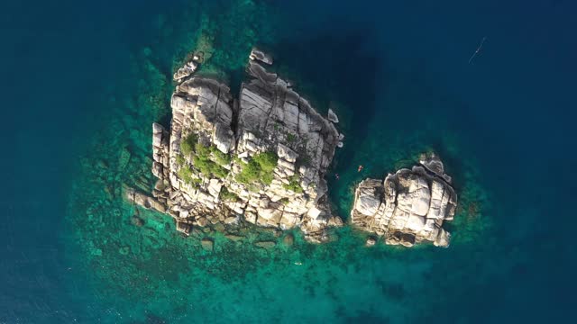 无人机俯瞰海洋和海滩上的岩石，Kho Tao岛泰国飞行在清澈的蓝色海水上方令人惊讶的低航拍海面。股票视频视频素材