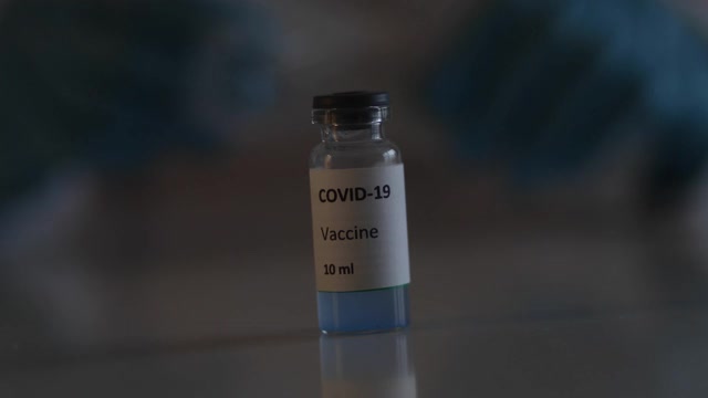 Covid - 19疫苗接种概念、研制和创造，实验室医生或科学家持有单剂新型冠状病毒疫苗，注射器和安瓿与SARS-CoV-2疫苗接种视频素材