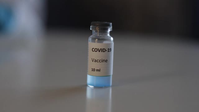 Covid - 19疫苗接种概念、研制和创造，实验室医生或科学家持有单剂新型冠状病毒疫苗，注射器和安瓿与SARS-CoV-2疫苗接种视频素材