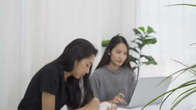 两个女孩在学习，通过笔记本电脑打视频电话。视频素材