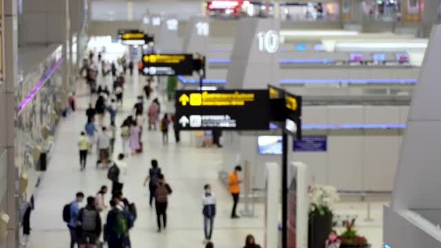 乘客在机场行走的高光镜头。新冠肺炎疫情后开通航空旅行。每个人都戴上防毒面具。模糊焦点视频素材