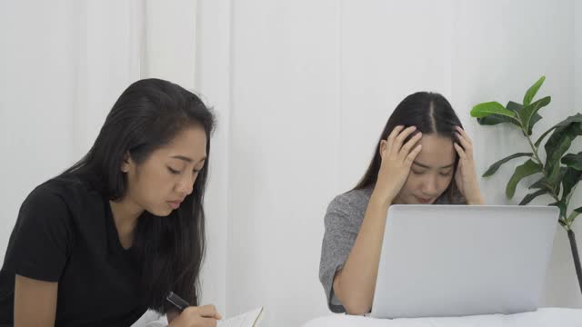 两个女孩在学习，通过笔记本电脑打视频电话。视频素材