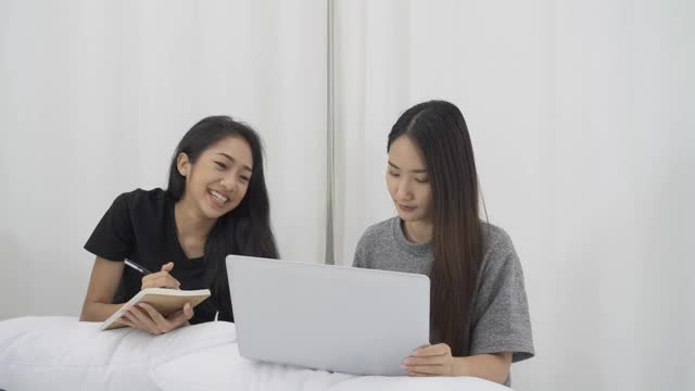 两个女孩在学习，通过笔记本电脑打视频电话。视频素材