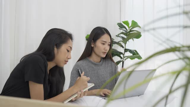 两个女孩在学习，通过笔记本电脑打视频电话。视频素材