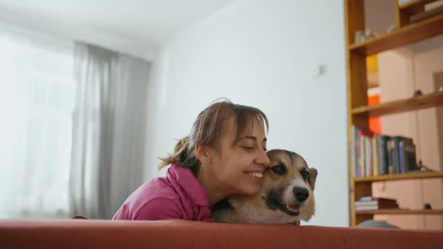 年轻女子抚摸着她可爱的威尔士柯基犬视频素材