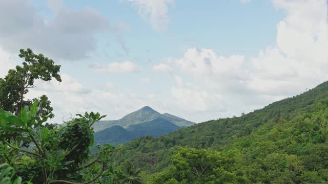 长时间的山顶有绿色的热带森林。云飞快地飞逝。一个晴朗的晴天。蓝色的天空。视频素材