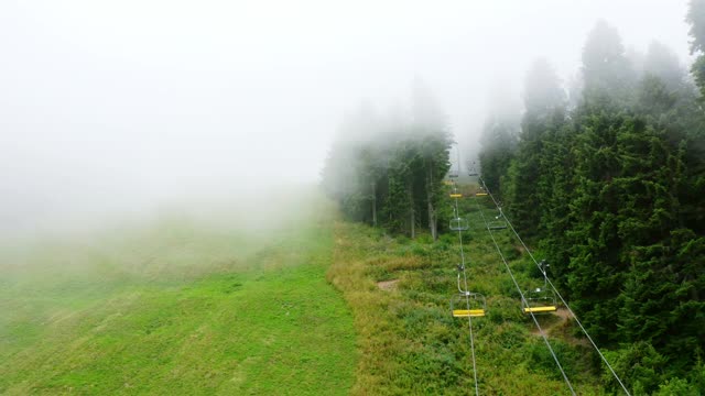 无人机航拍的雾山森林和空的滑雪缆车在夏季，4k视频素材