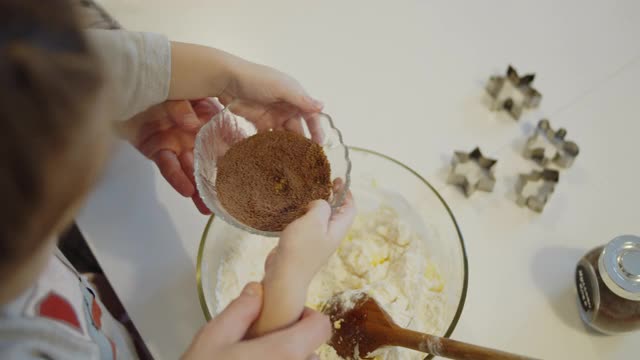 年轻的母亲和女儿一起在厨房里烤饼干视频素材