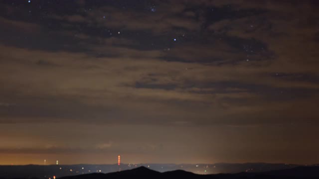 在夜晚的星空下，云在蓝岭山脉上移动，时间流逝视频素材