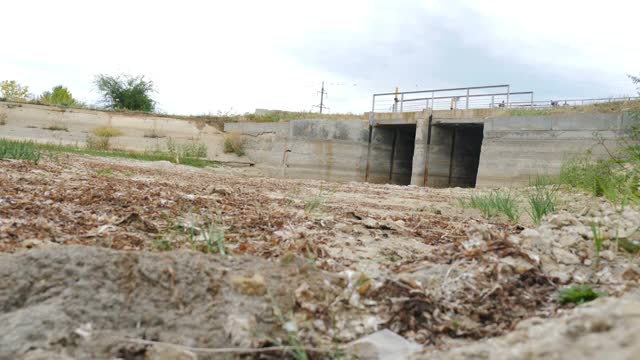 生态灾难。土地龟裂，干涸的湖或河上空桥。土地被侵蚀和全球变暖-气候变化和生态问题。全高清视频素材