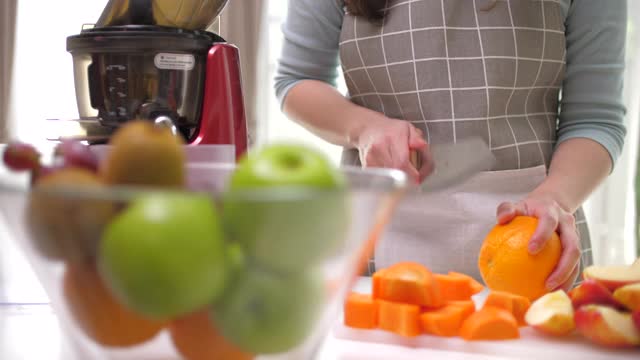 妇女准备蔬菜和水果冷榨果汁视频素材