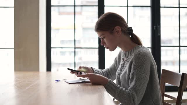 年轻女子通过计数和核对预算视频素材