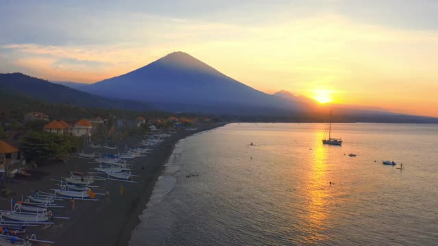 日落风景的海洋和阿贡火山从阿米德村，印尼巴厘岛。4 k鸟瞰图视频素材