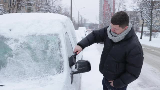 一场大雪过后，司机把车上的积雪清理干净。视频素材