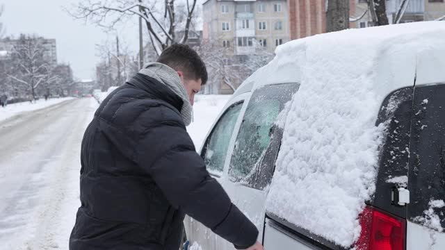 一场大雪过后，司机把车上的积雪清理干净。视频素材