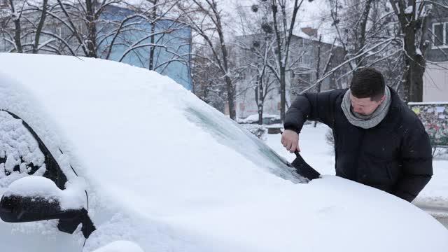 一场大雪过后，司机把车上的积雪清理干净。视频素材