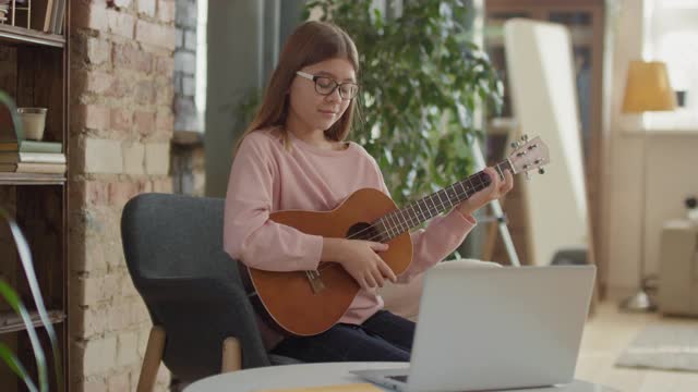 女孩玩尤克里里琴视频素材