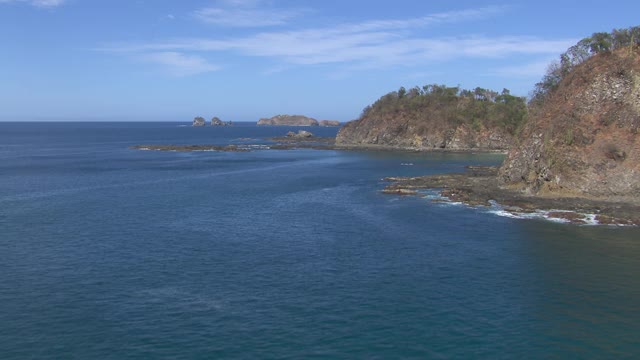 鸟瞰图的岩石海岸线和遥远的布鲁梅尔岛远离哥斯达黎加海岸。视频素材