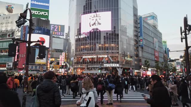 日本东京，忙碌拥挤的亚洲人和游客在涉谷十字路口拍照。日本地标旅游景点，冬季旅游生活方式，或亚洲城市生活视频素材