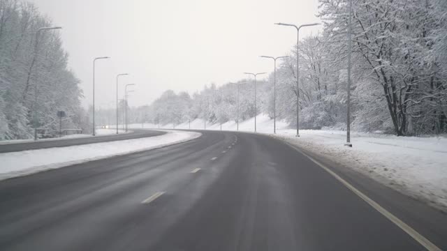 在暴风雪后的道路上驾驶汽车。美丽的雪树和冬天的风景。视频素材