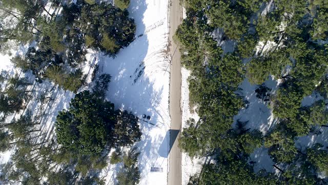 无人机拍摄的树间积雪的道路。西班牙视频素材