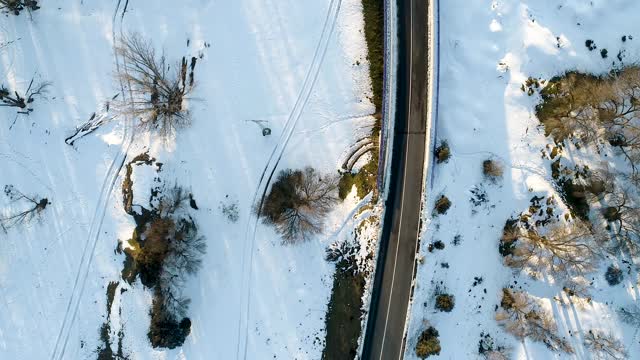 无人机拍摄的树间积雪的道路。西班牙视频素材