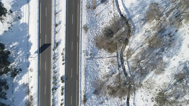 无人机拍摄的树间积雪的道路。西班牙视频素材