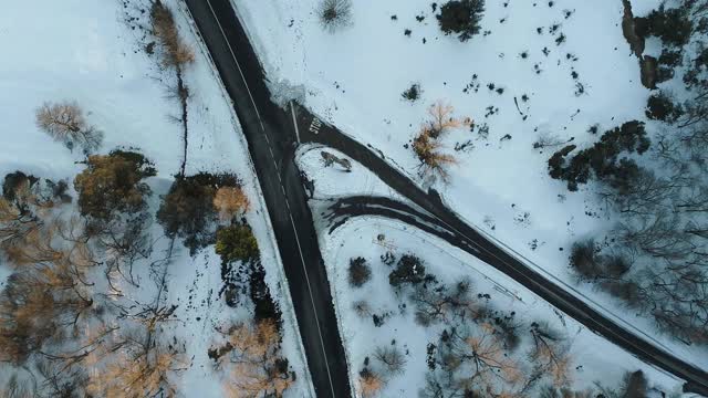 无人机拍摄的树间积雪的道路。西班牙视频素材