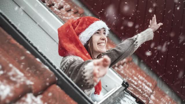 年轻女子快乐的雪在她的屋顶房间。静态图片与移动的雪。循环。Cinemagraph。视频下载