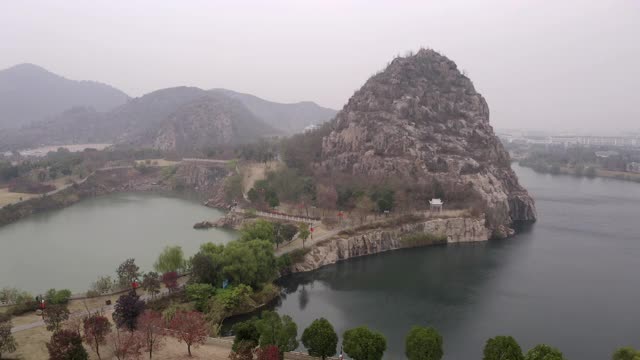 空中平移拍摄的湖泊与岩石形成的城市附近的天空，无人机飞过附近的山脉-苏州，中国视频素材