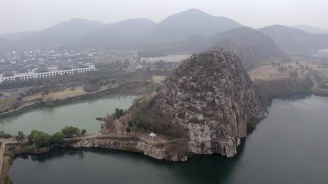 空中平移拍摄的岩石形成附近的湖泊对天空，无人机飞过附近的山脉-苏州，中国视频素材