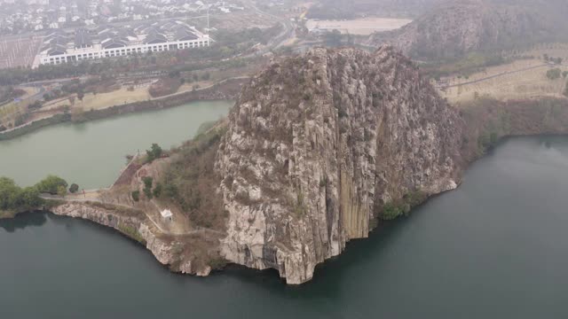 空中拍摄的岩石悬崖附近的湖泊对山，无人机下降附近的城市对天空-苏州，中国视频素材