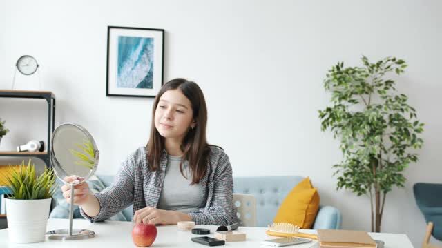 慈爱的母亲帮助十几岁的女儿化妆，化妆，享受在家的闲暇时光视频素材