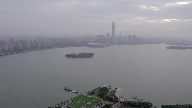 空中拍摄的金鸡湖的城市景观对多云的天空，无人机飞向城市的建筑物在日落-苏州，中国视频素材