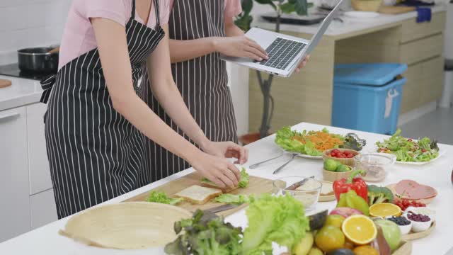 夫妻俩在家里一起在厨房做饭蔬菜沙拉视频素材