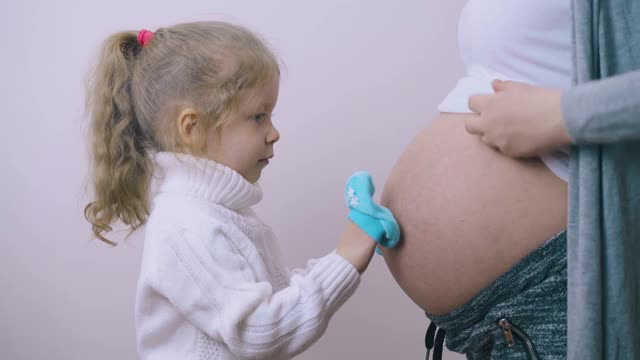 女孩在靴子里用手踩孕妇的肚子视频素材