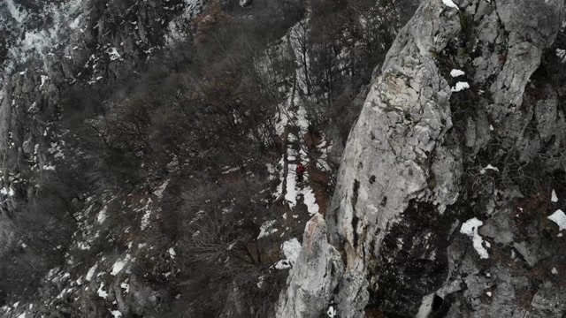 探险家在山顶，用无人机拍摄4k视频。这位登山者穿过一座山脉——冬季的风景视频素材画面2